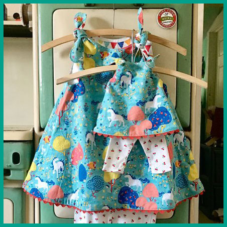 Picture of something you can make in Sewing 101 for Kids - matching outfit for a doll and a child. the outfit is a colorful reversible dress with coordinating leggings.